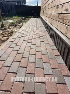 уложенная дорожка из тротуарной плитки брусчатка