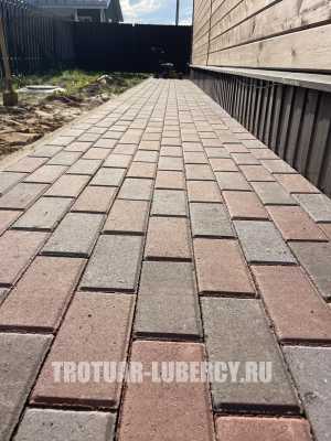 уложенная дорожка из тротуарной плитки брусчатка